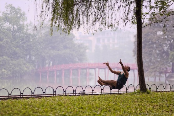Man performing Tai Chi Chuan during early morning exercise beside Hoan Kiem Lake, Hanoi, Vietnam