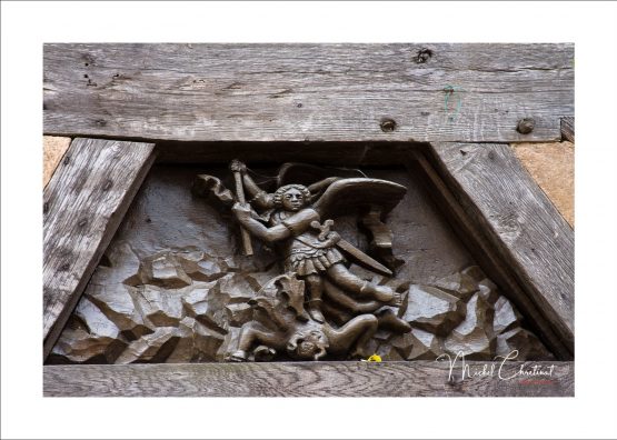 Photo d'une scuplture en bois à la facade d'une maison  à gerberoy